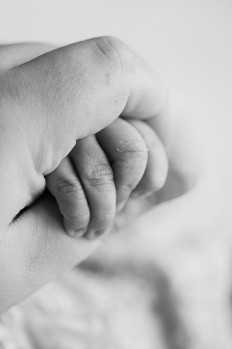 Vauvan ja äidin kädet, vastasyntyneen vauvan pienet sormet.